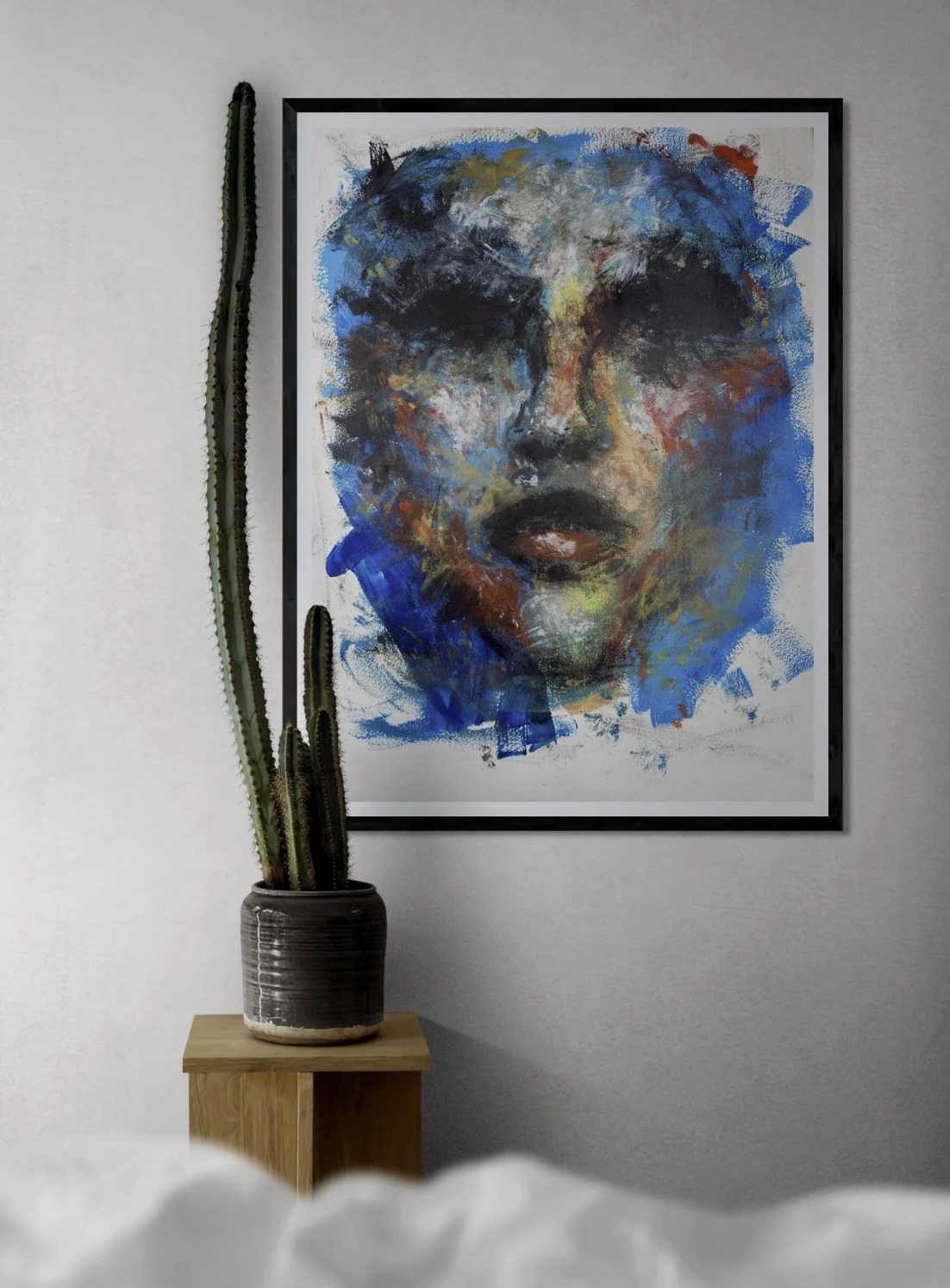 Untitled work on paper — blue and black face, framed.